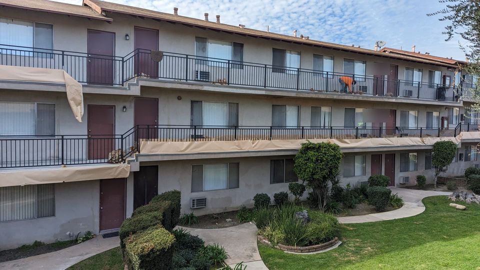 Arcadia apartment building during repairs with protective covers over walkway edges and new dark railings installed.