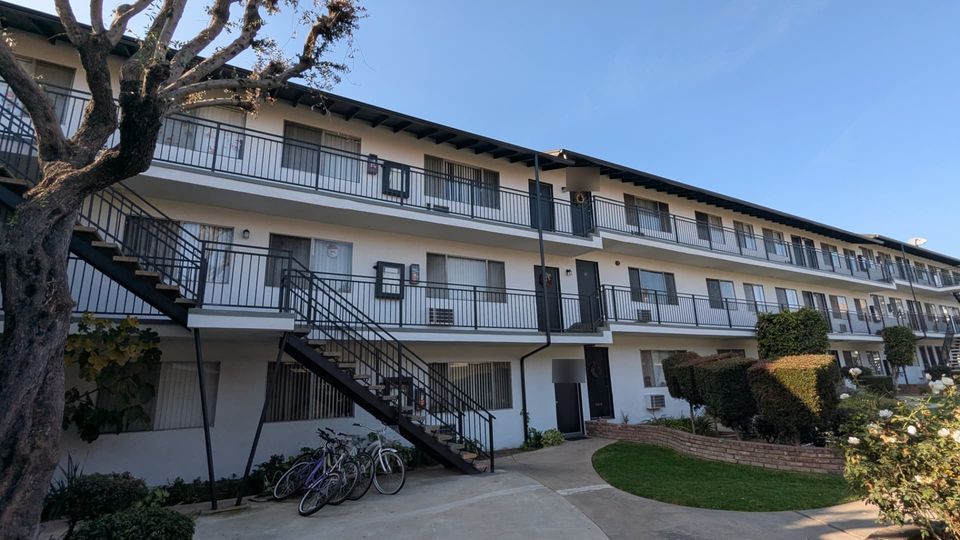 Completed Arcadia apartment walkways with repaired exterior edges, dark metal railings and restored finishes.