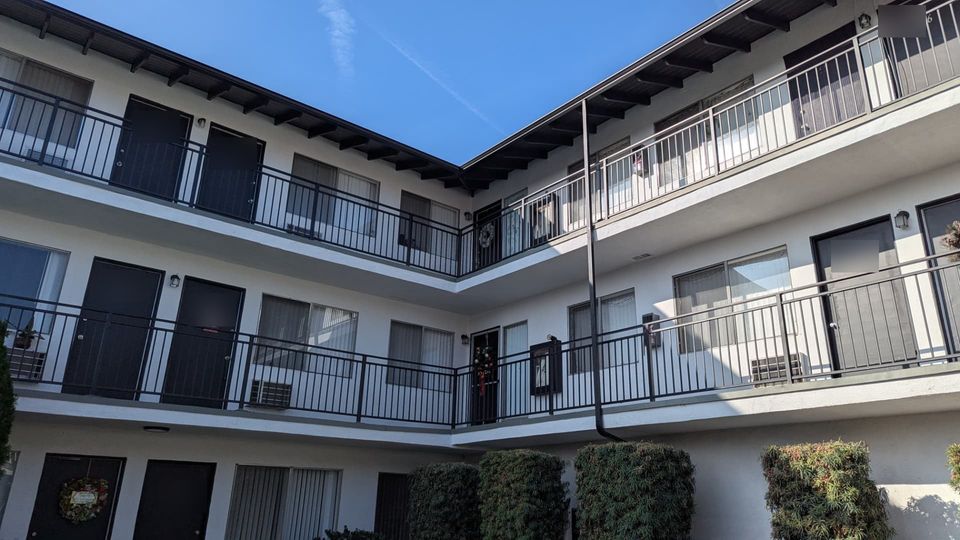 Completed corner walkways with consistent railings, restored edges and clean exterior finishes.